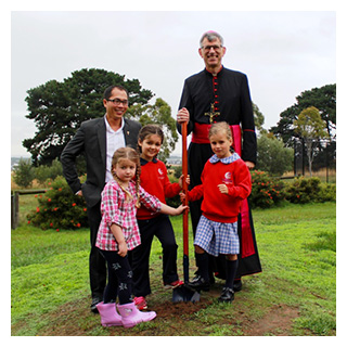 Bishop Mark Edwards blesses the building site for the new Lisieux Catholic primary school in Torquay with Parish Priest Father Linh Tran and children