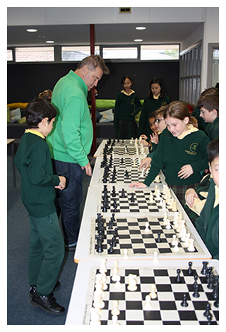 An image of Chess Master, Leonid Sandler and students playing chess