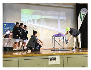 students being awarded first prize for building the strongest bridge