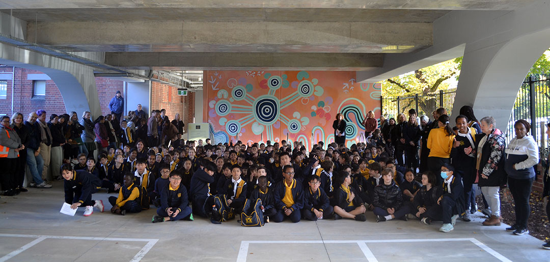 Group photo of students in front of the mural
