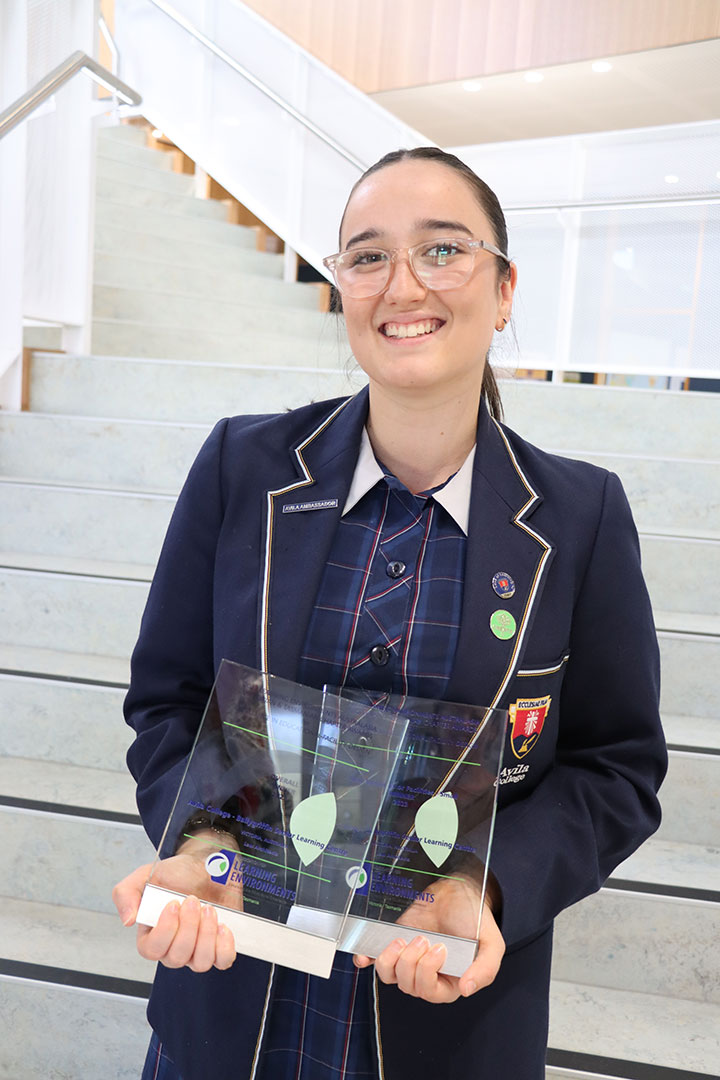 student posing with the awards