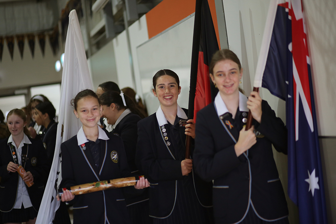 a procession led by students carrying flags