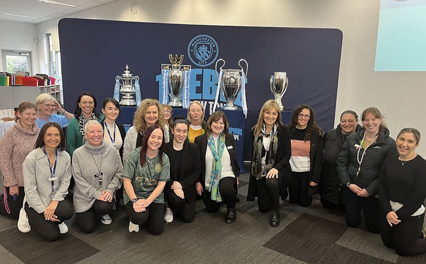 Staff with the Manchester City FC trophies