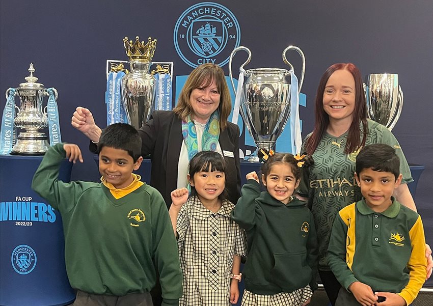 students with the Manchester City FC trophies